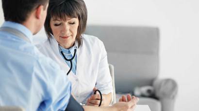 Female doctor measuring man blood pressure