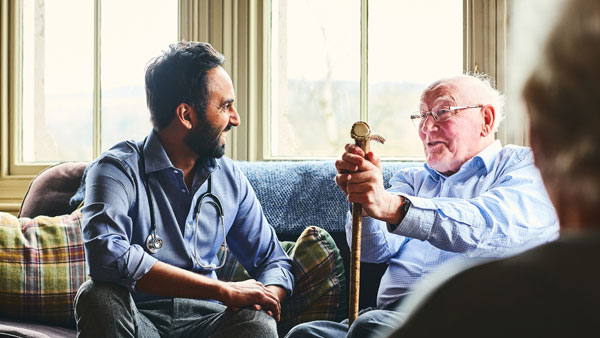 Médecin souriant visitant un homme senior à la maison